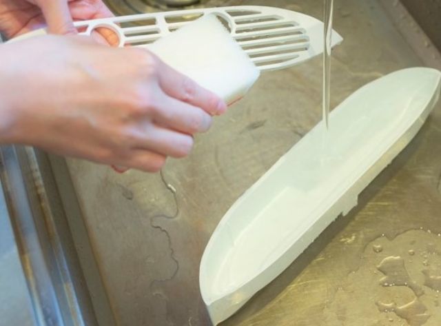 受け皿を食器用洗剤とスポンジなどで洗う